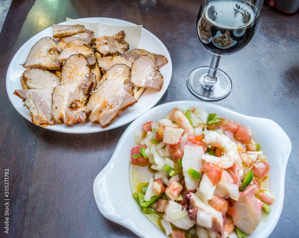 Plates of tapas and glass of red wine in Sevilla